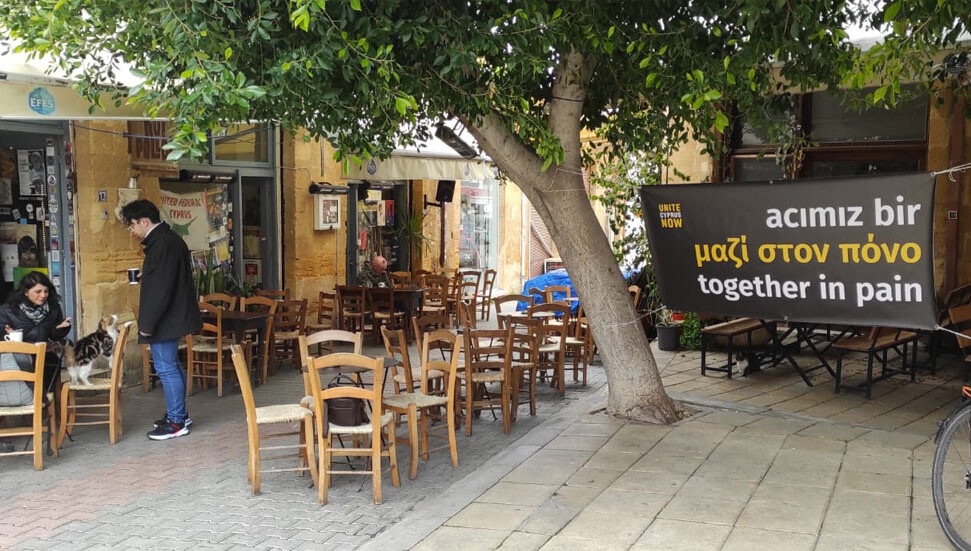 Unite Cyprus Now, birçok bölgeye üç dilde "acımız bir" yazan pankartlar astı